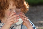 Meisje drinkt lekkere melk in het gras