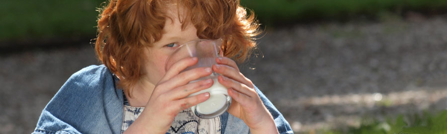 Meisje drinkt lekkere melk in het gras